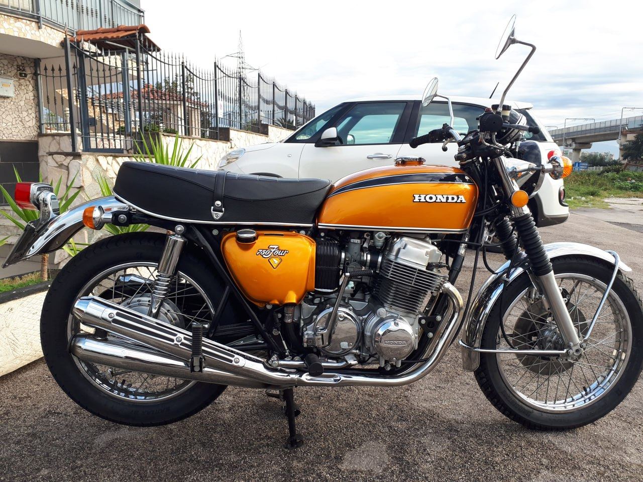 Moto classica a quattro cilindri con serbatoio arancione e cromature